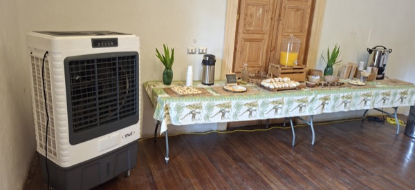 Enfriador de aire evaporativo junto a una mesa de desayuno